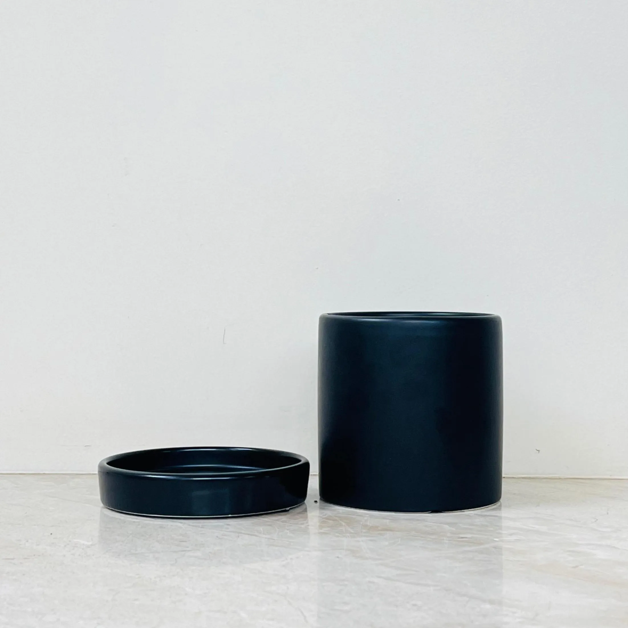 Cylindrical matte black plant pot for indoor use