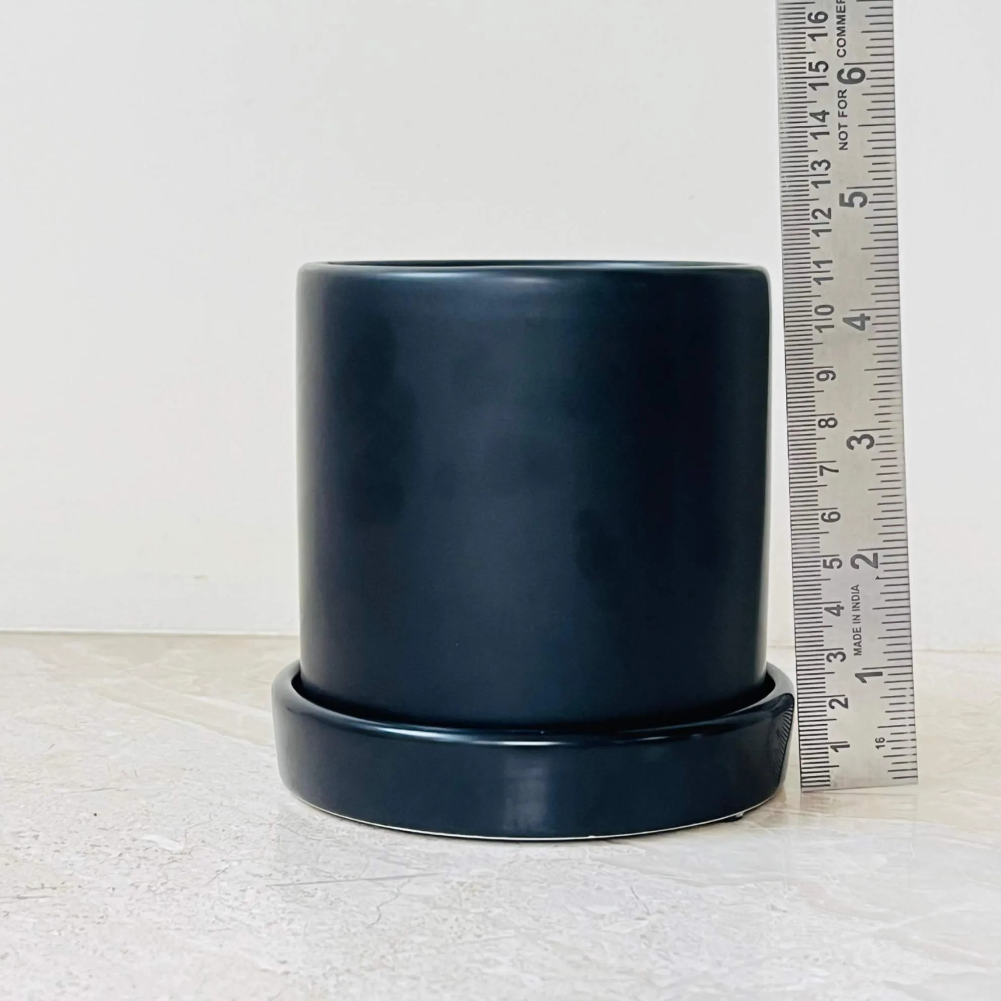 Cylindrical matte black plant pot for indoor use